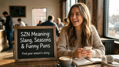 Woman smiling in a cozy cafe holding a phone beside a chalkboard sign about szn meaning and slang.